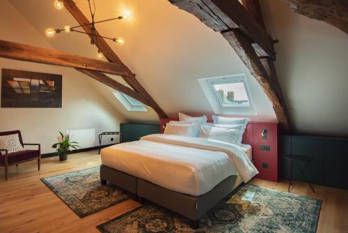 a bedroom with a king sized bed in an attic at Luxury cosy family nest in the medieval town in Dinan
