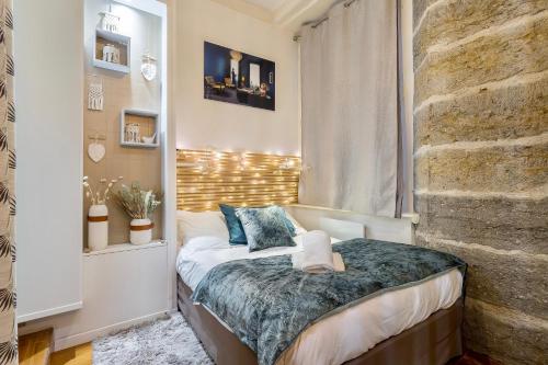 - une petite chambre avec un lit et un mur en briques dans l'établissement Host inn Lyon - Appartement de Luxe aux Terreaux & Jacuzzi, à Lyon