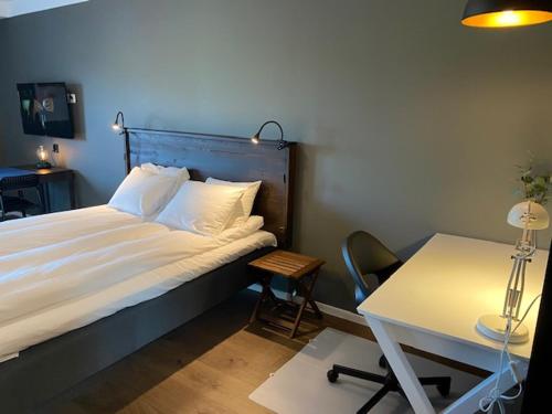 a bedroom with a bed and a table and a desk at Magnolia House Norrviken in Sollentuna