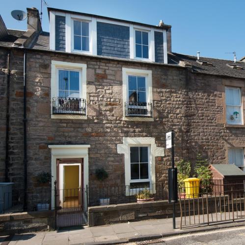 a brick house with a yellow door and windows at 7 Bedroom Townhouse in Edinburgh