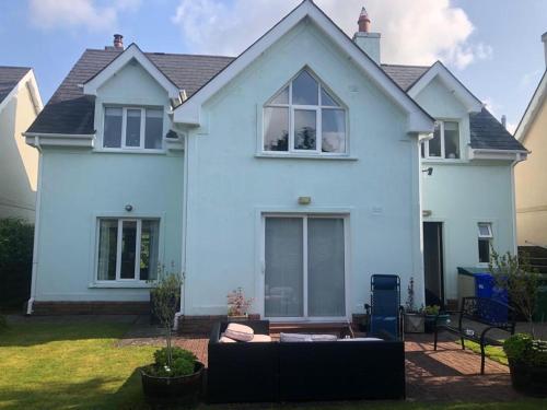 Casa blanca con sofá en el patio delantero en Foxborough BnB, en Droichead an Chaisleáin