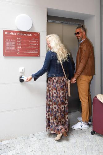 a woman standing in front of a door with a man at Apartmenthaus Nr 1 in Lienz