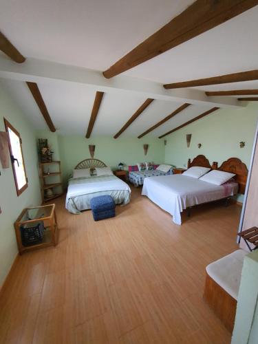 a large bedroom with two beds and a wooden floor at Casa de campo Padul in Granada