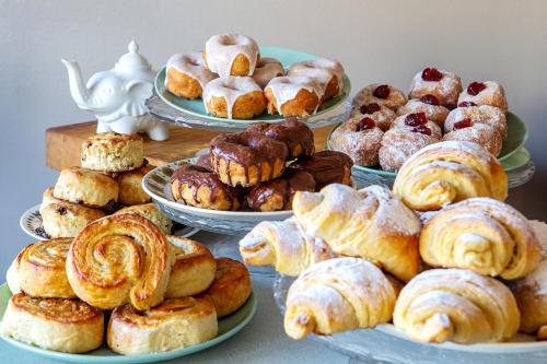 a bunch of pastries on plates on a table at The Bear Bread Bakery B&B, Ensuite rooms above the Bakery, Colyton in Colyton