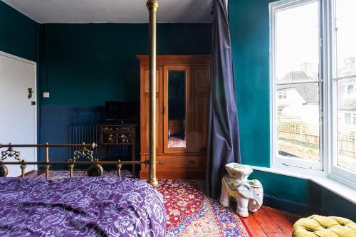 a bedroom with a purple bed and a window at The Bear Bread Bakery B&B, Ensuite rooms above the Bakery, Colyton in Colyton