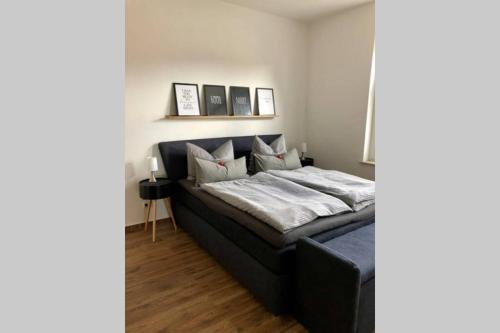 um quarto com uma cama preta com almofadas em Liebevoll sanierte, großzügige Stadtwohnung, 70 qm em Quedlinburg