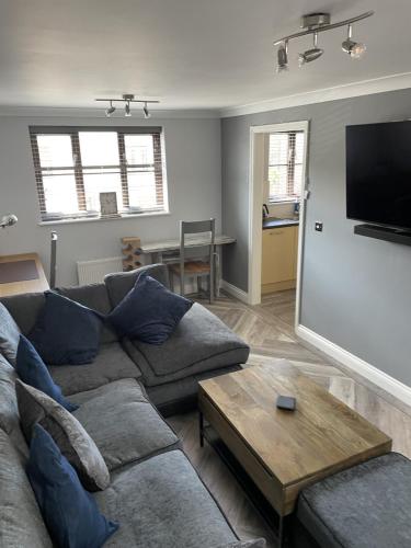 a living room with a couch and a table at Burry Port Harbour Apartment in Burry Port
