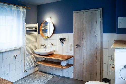 a bathroom with a sink and a mirror at Ferien unnern Appelboom (80m2 Wohnung mit großem Garten) in Groß Kordshagen