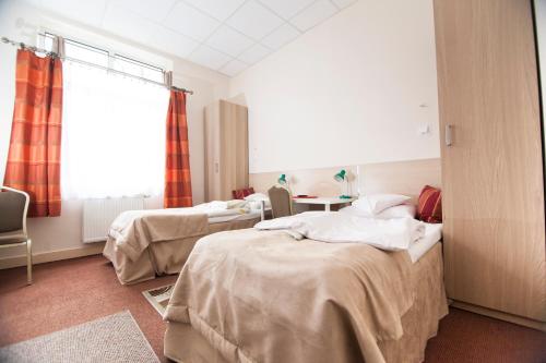 a hospital room with two beds and a table at Akacja Pokoje Gościnne in Kraków