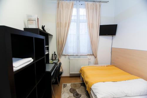 a small bedroom with a bed and a window at Akacja Pokoje Gościnne in Kraków