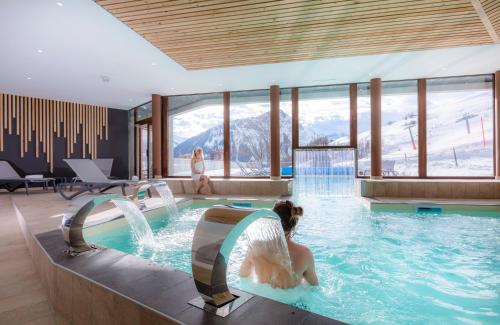 une femme dans une piscine d'une station de ski dans l'établissement Résidence Club mmv L'Etoile des Sybelles ****, au Corbier