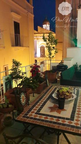 a patio with potted plants and a table with a plate of food at DonMattè - Charme & Rooms in Conversano