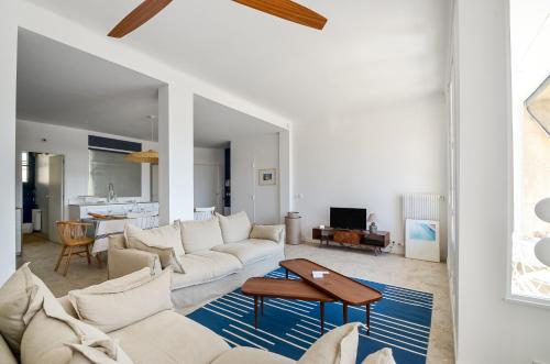 a living room with a white couch and a table at MASSILIA BLUE - Grand appartement refait à neuf avec vue sur le Vieux Port in Marseille