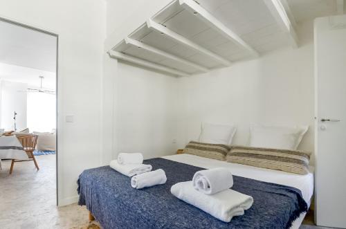 - une chambre blanche avec un lit et des serviettes dans l'établissement MASSILIA BLUE - Grand appartement refait à neuf avec vue sur le Vieux Port, à Marseille