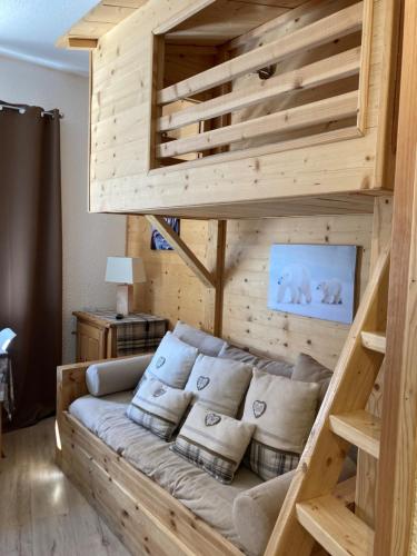 een grote houten bank in een woonkamer bij travelski home select - Résidence Boedette in Les Menuires