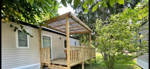 une cabine avec une terrasse en bois sur le côté d'une maison dans l'établissement Paris Camping Ile du Roi, à Triel-sur-Seine