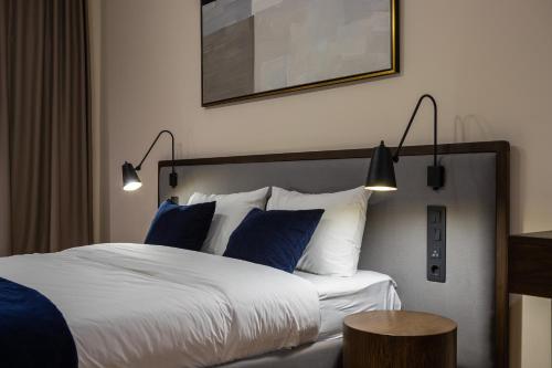 um quarto de hotel com uma cama com almofadas azuis em On The Square em Lviv