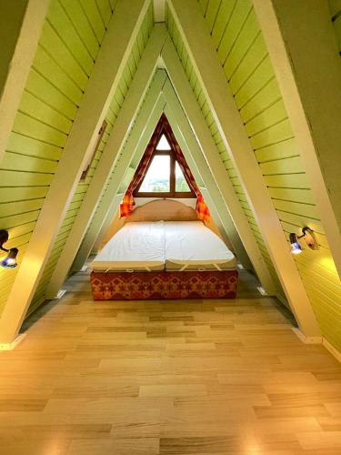a bed in the middle of a room with a window at Ferienhäuser 6 & 24 in Freyung