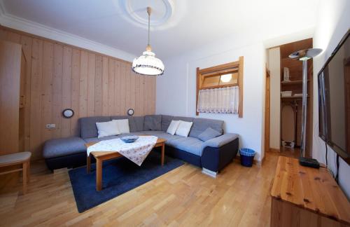 a living room with a blue couch and a table at Appartement Heidi in Viehhofen