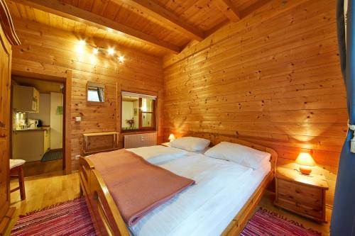 a bedroom with a bed in a wooden cabin at Appartement Heidi in Viehhofen