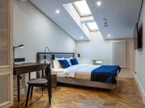 a bedroom with a bed and a desk and skylights at On The Square in Lviv