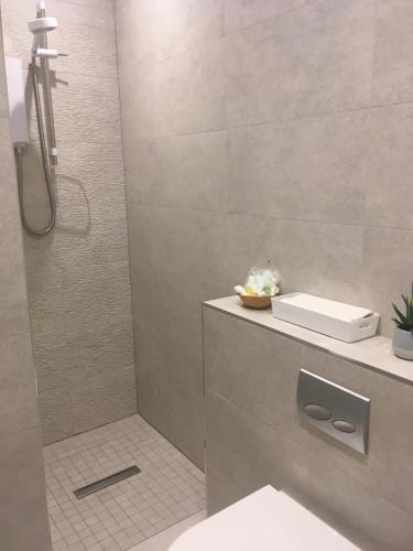 a bathroom with a shower with a toilet and a sink at The Conifers in Edinburgh