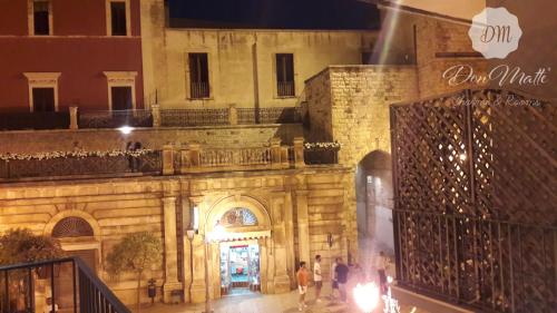 a building with people walking in front of it at night at DonMattè - Charme & Rooms in Conversano