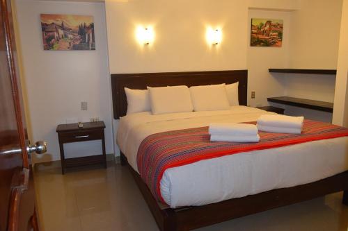 Quilla House Ecologico في ماتشو بيتشو: غرفة نوم عليها سرير وفوط