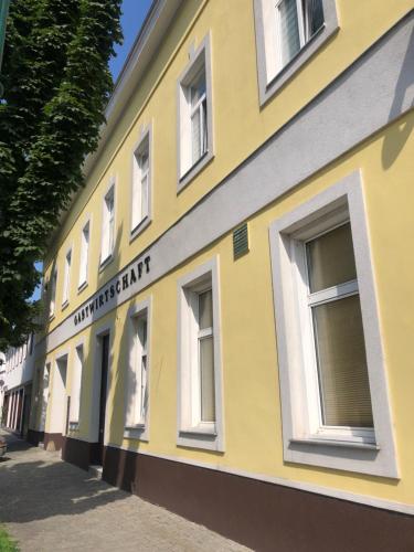 ein gelbes Gebäude mit weißen Fenstern auf einer Straße in der Unterkunft Wohnung in Wien in Wien