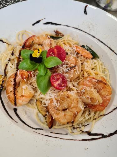 a plate of pasta with shrimp and tomatoes on it at Landhotel Weisses Röß`l in Adorf