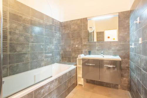 une salle de bain avec une baignoire et un lavabo et une baignoire dans l'établissement L'Olivier - bel appartement au calme à 2 pas du Vieux Port, à Marseille