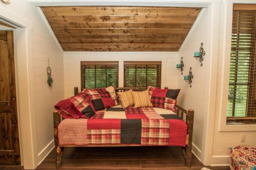 a living room with a couch and two windows at NEW FOREST COTTAGE W/GRILL & DECK:HIKE, FISH, GOLF in Glenville
