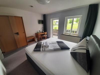 a bedroom with a large white bed with a window at Landhotel Weisses Röß`l in Adorf