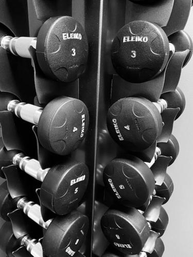 a bunch of dumbbells hanging in a gym at Magnolia House Norrviken in Sollentuna
