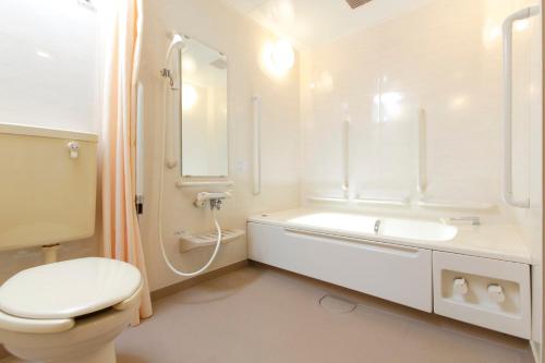La salle de bains blanche est pourvue de toilettes et d'un lavabo. dans l'établissement FLEXSTAY INN Shinurayasu, à Urayasu