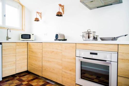 - une cuisine avec des placards en bois et un four dans l'établissement Villa Cléo-Jean, à Cayeux-sur-Mer