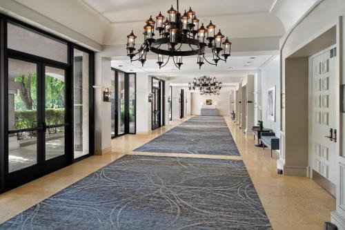 a hallway with a blue rug and a chandelier at Hyatt Regency Westlake in Westlake Village