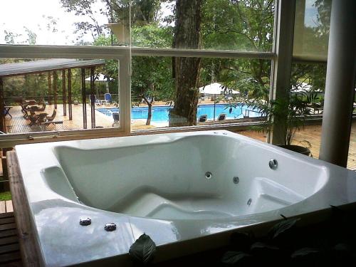 y baño con bañera y vistas a la piscina. en Gran Hotel Tourbillon & Lodge en Puerto Iguazú
