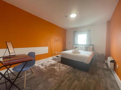 Schlafzimmer mit einem Bett, einem Tisch und einem Fenster in der Unterkunft Neon 160 in Swansea