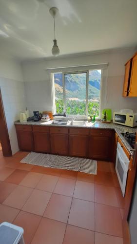 Madalena do MarにあるApartamento Vai Vemのキッチン(シンク付)、大きな窓が備わります。