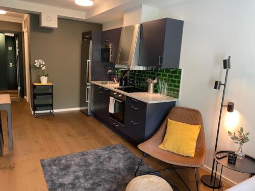 a kitchen with black cabinets and a yellow pillow at Magnolia House Norrviken in Sollentuna