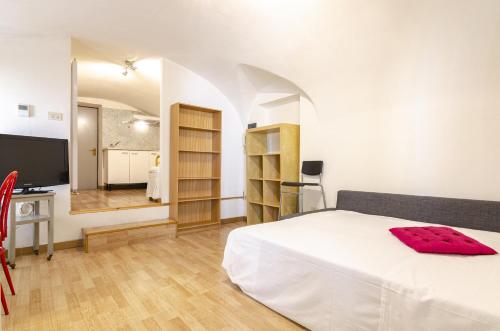 een slaapkamer met een wit bed en een televisie bij Appartamento piccolo nel cuore della citta' by Wonderful Italy in Bologna