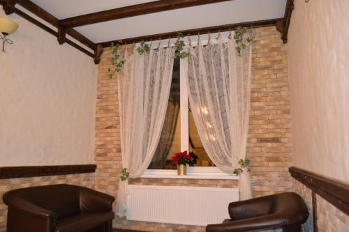 a room with two chairs and a window with curtains at Zolota Forel Hotel in Korostov
