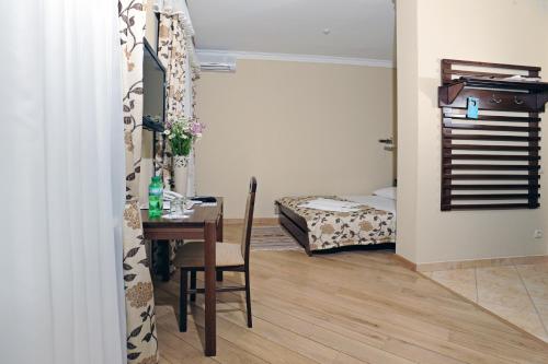 a room with a table and a bedroom with a bed at Zolota Forel Hotel in Korostov