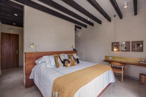 a bedroom with a large bed and a desk at Cantera 1910 Hotel Boutique, Destination Hotel in San Miguel de Allende