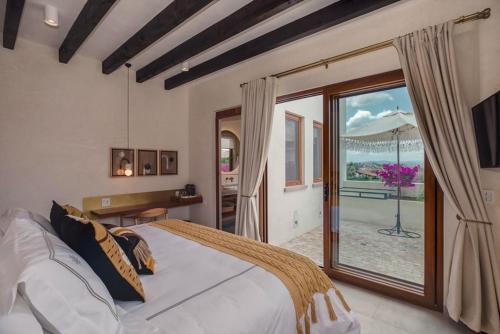 a bedroom with a large bed and a large window at Cantera 1910 Hotel Boutique, Destination Hotel in San Miguel de Allende