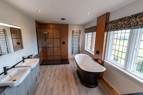 a bathroom with two sinks and a bath tub at Sneaton Castle in Whitby