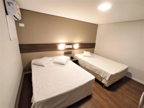 a hotel room with two beds and lights on the wall at Granville Hotel in Curitiba