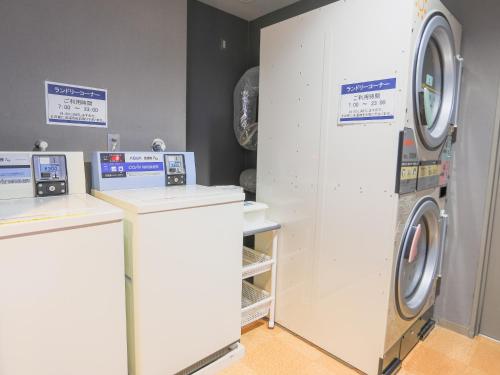 a white laundry room with a washer and dryer at Castle Inn Sendai in Sendai
