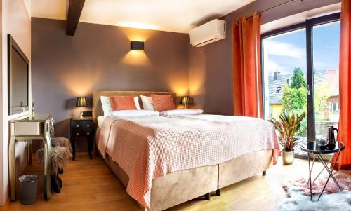 une chambre avec un lit et une grande fenêtre dans l'établissement H&G Boutique Apartments, à Oświęcim